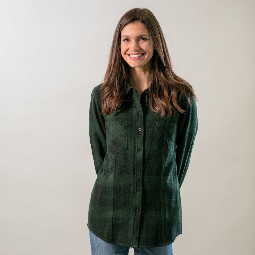 Woman with long brown hair in a Pladra Women's Every Day Elite Flannel Shirt—Humboldt Green, smiling at the camera.
