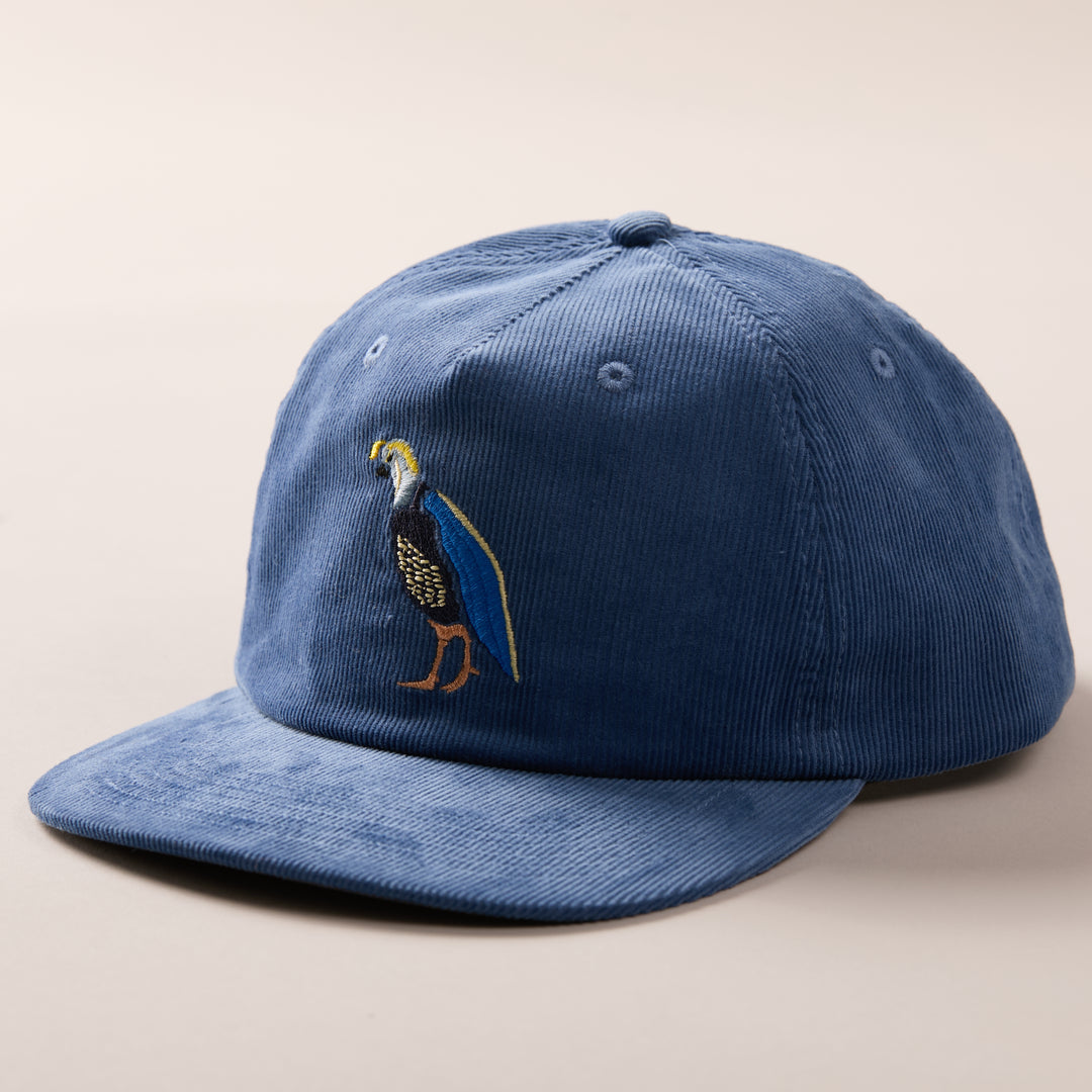 Pladra Quail Corduroy Hat- Blue: embroidered bird, cotton corduroy, adjustable fit, shown on a neutral background.