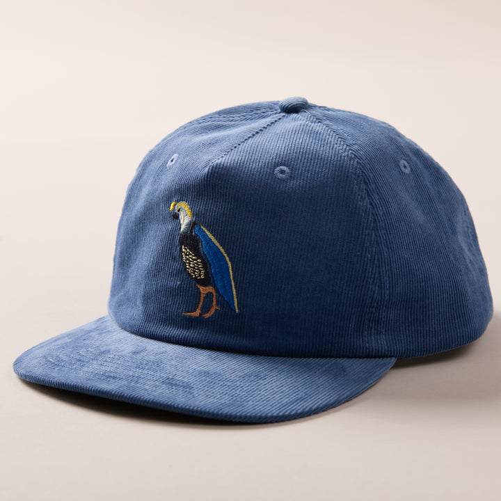 Pladra Quail Corduroy Hat- Blue: embroidered bird, cotton corduroy, adjustable fit, shown on a neutral background.