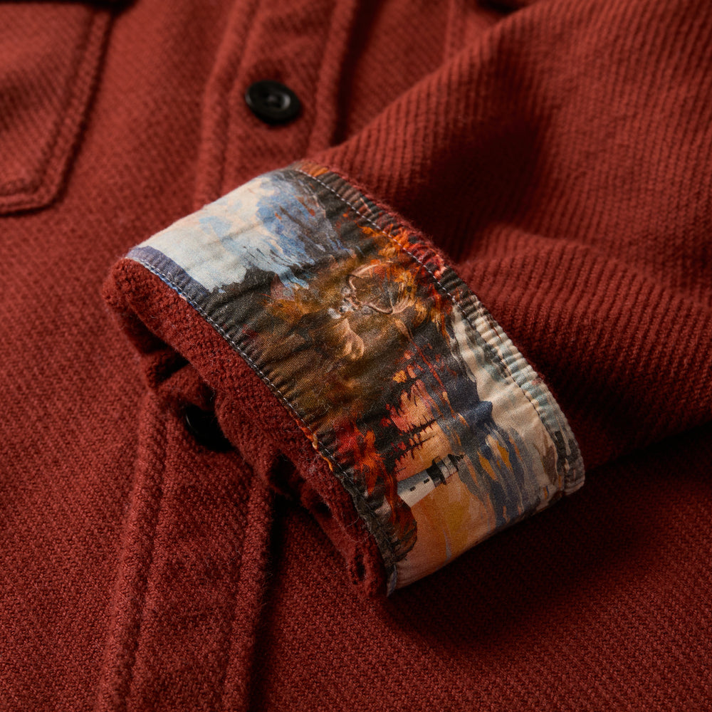 The Pladra Men's Fireside Flannel in Brick Red features a cuff turned up to reveal a colorful printed lining.