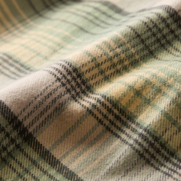 A detailed view of the Men’s Every Day Flannel Shirt in Cactus Green shows its soft Portuguese flannel with a green, beige, and cream plaid pattern—ideal as a cozy, stylish staple for any men’s flannel wardrobe.