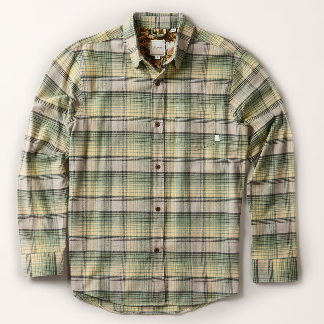 The Men's Every Day Flannel Shirt- Cactus Green features long sleeves, a left chest pocket, brown buttons, and a green, yellow, and gray plaid pattern—ideal for daily wear.