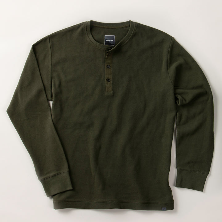 Men's Elko Henley by Pladra in forest green, cotton waffle knit, 3 buttons, long sleeves, laid flat on light surface.