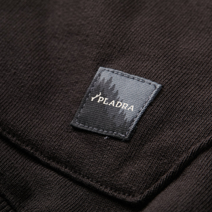 A close-up of a Pladra tag on the Men's Sierra Hoodie - Charcoal Black, perfect for your premium outerwear look.