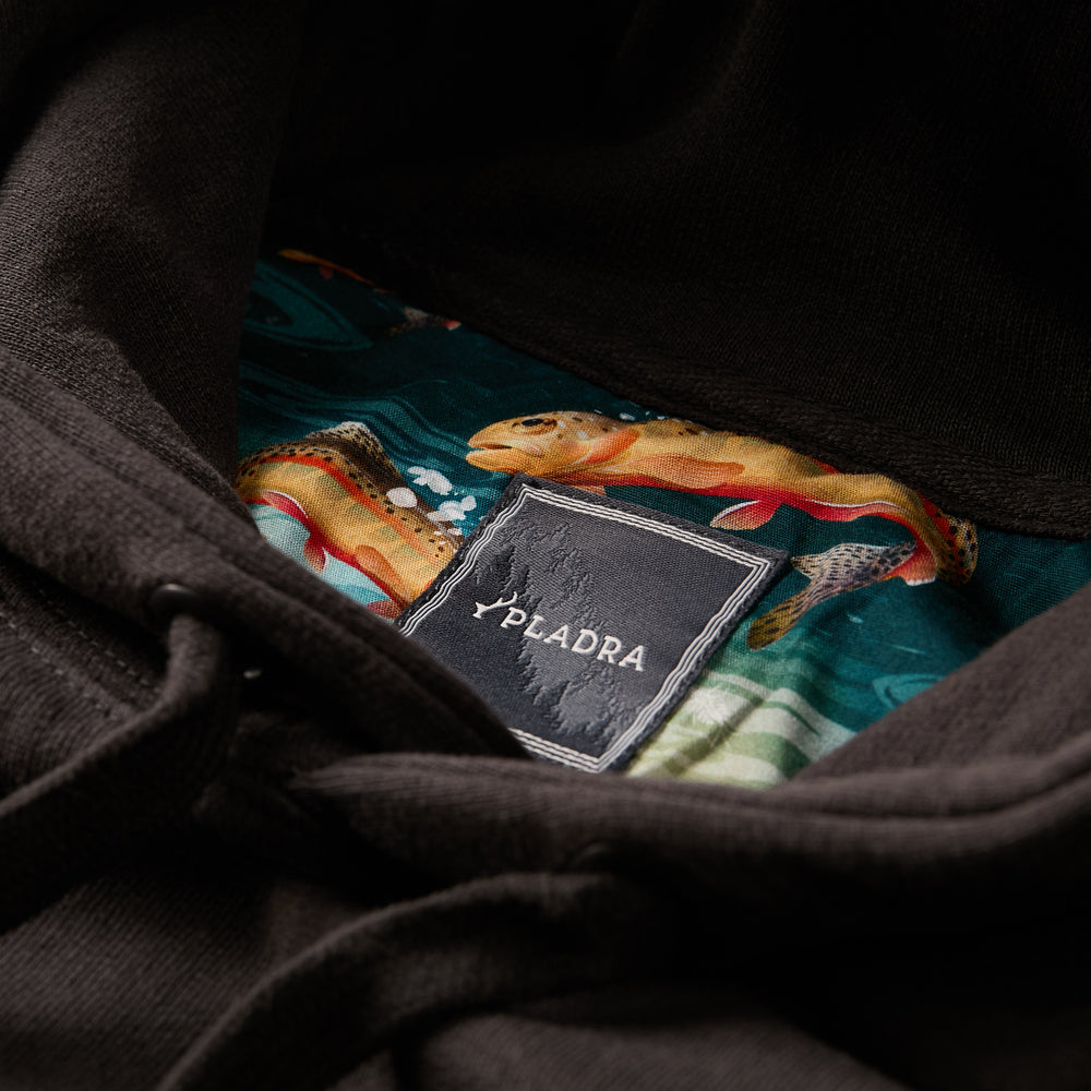 Close-up of a Pladra Men's Sierra Hoodie- Charcoal Black tag with colorful fish pattern lining inside the hood.