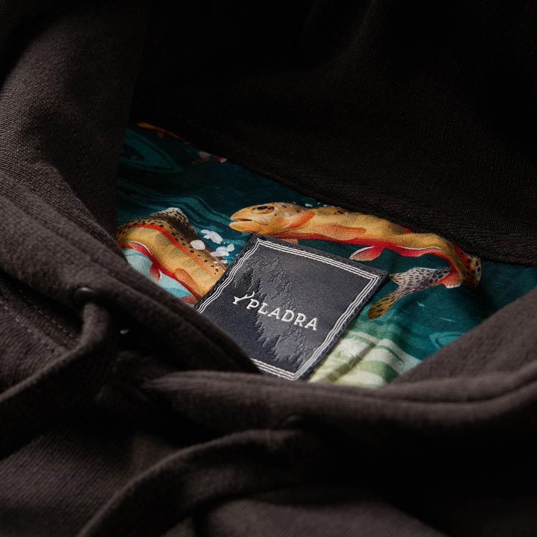 Close-up of a Pladra Men's Sierra Hoodie- Charcoal Black tag with colorful fish pattern lining inside the hood.