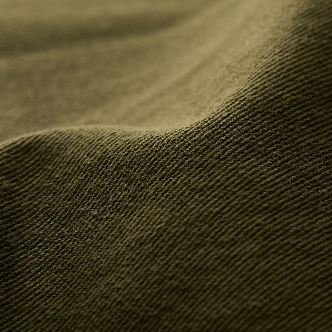 Close-up of hunter green, ribbed fabric with gentle folds, featured on Pladra&