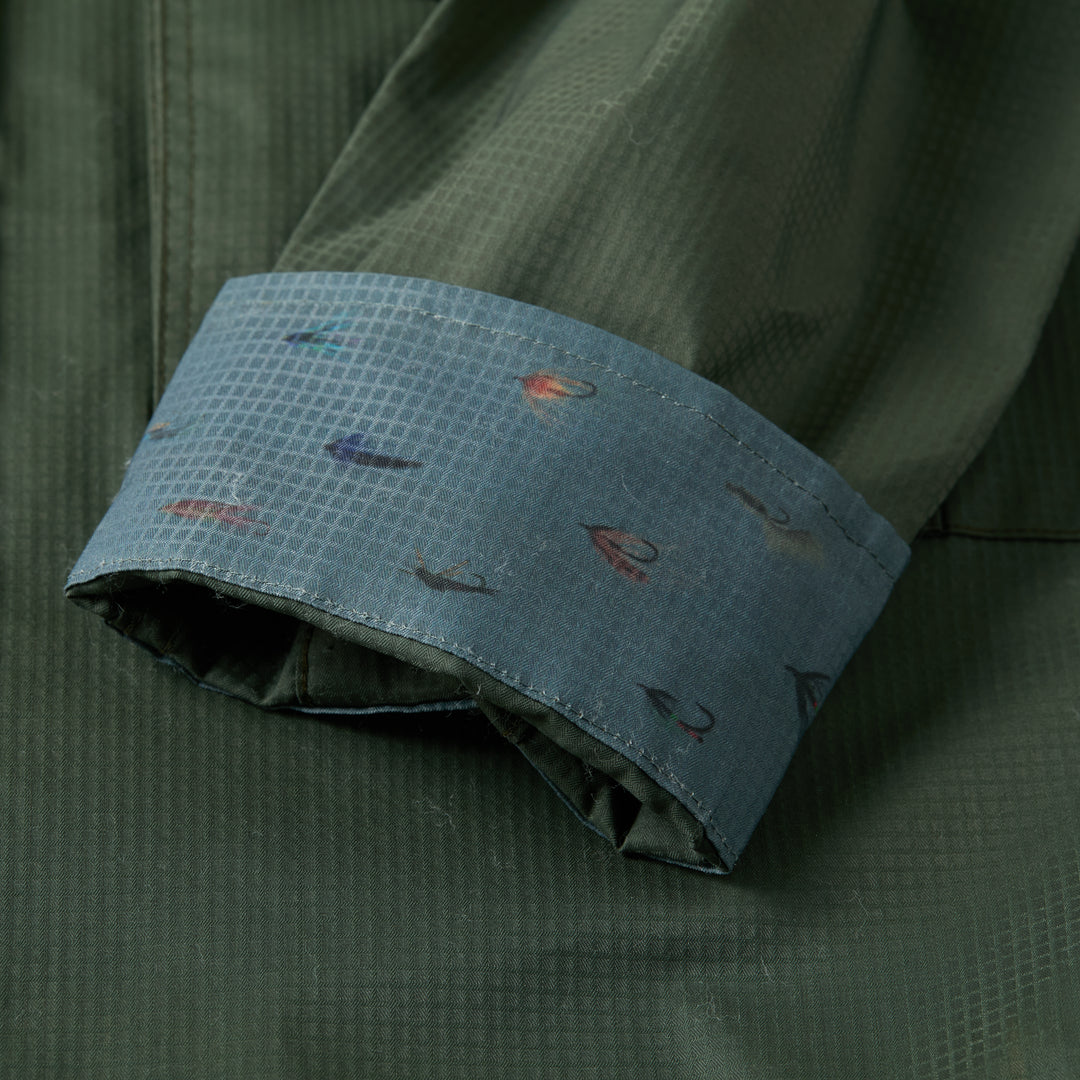 A quick-drying Kombu Green Pladra Yuba fishing shirt with a blue cuff and subtle planet and star pattern.