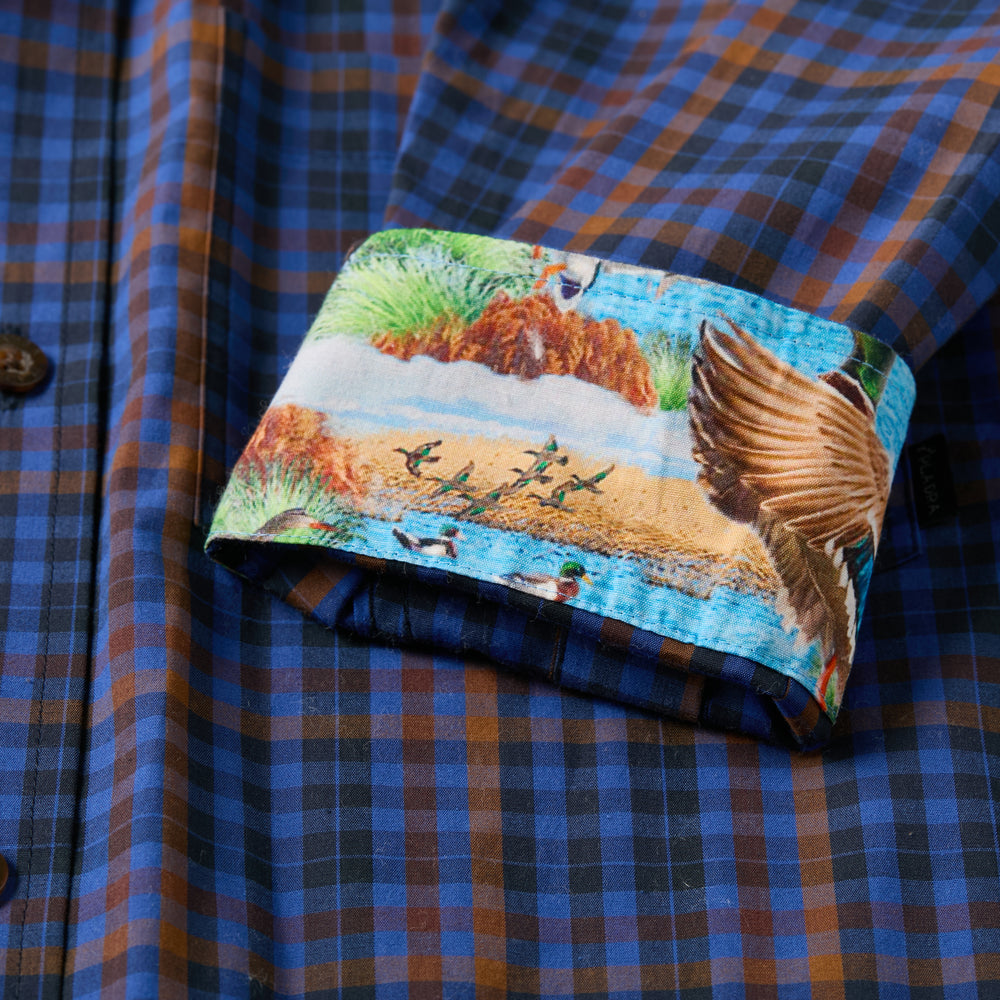 The Pladra Men's Tailwinds Shirt in Lagoon Blue features blue and brown plaid with a lakeside duck print cuff.