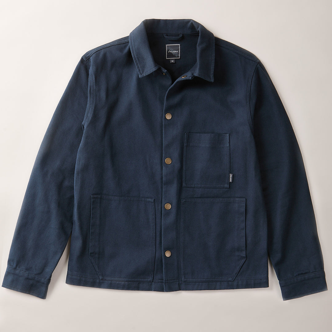 The Men's Sequoia Chore Coat in Midnight Blue features cotton twill fabric, a collar, metal buttons, and three front patch pockets—a timeless staple in men's workwear.