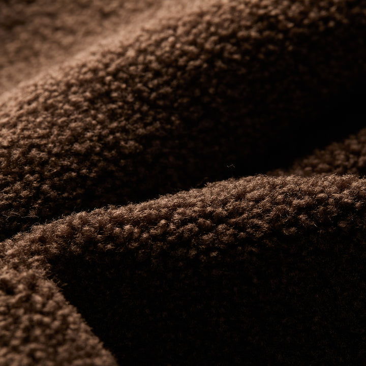 A close-up of soft, textured midnight blue fabric with a fuzzy, wool-like surface, featuring detailed fibers and folds—perfect for cozy comfort in the Men's Ironwood Sherpa Jacket.