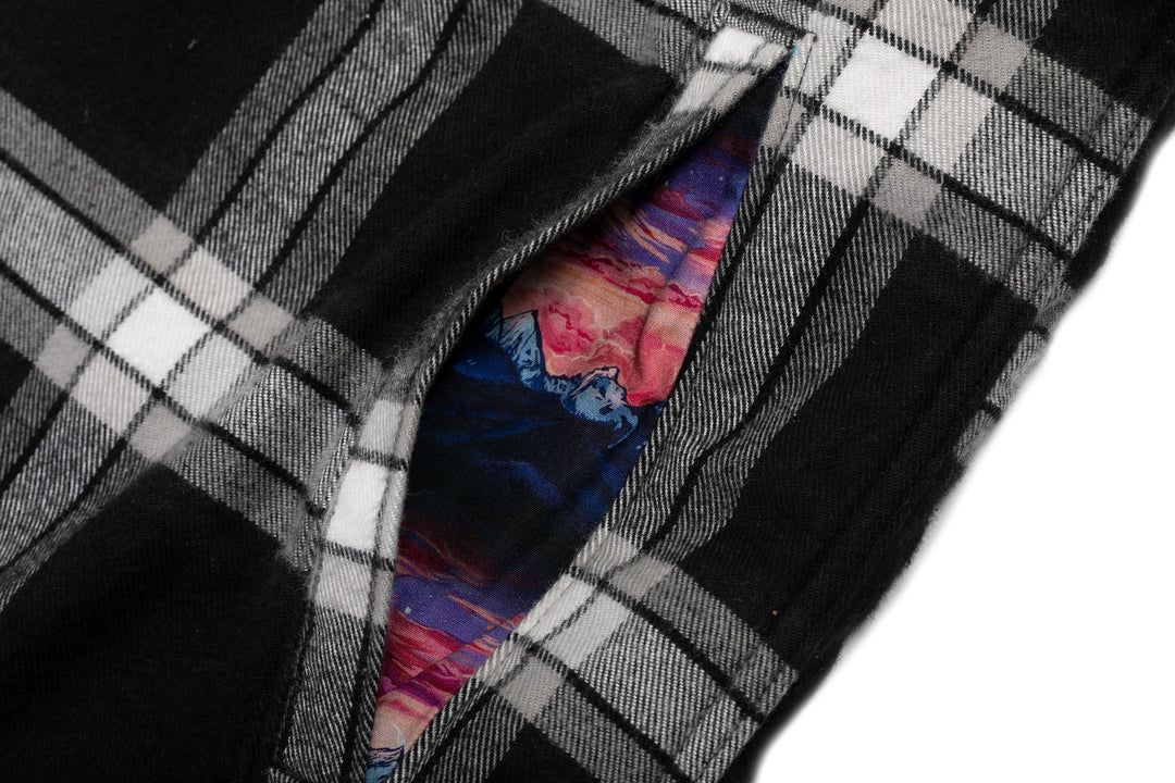 A close-up of the Pladra Women’s Northwood Sherpa Flannel Jacket—RP Onyx Black pocket and Rachel Pohl lining.