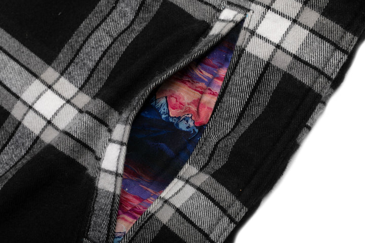 A close-up of the Pladra Women’s Northwood Sherpa Flannel Jacket—RP Onyx Black pocket and Rachel Pohl lining.