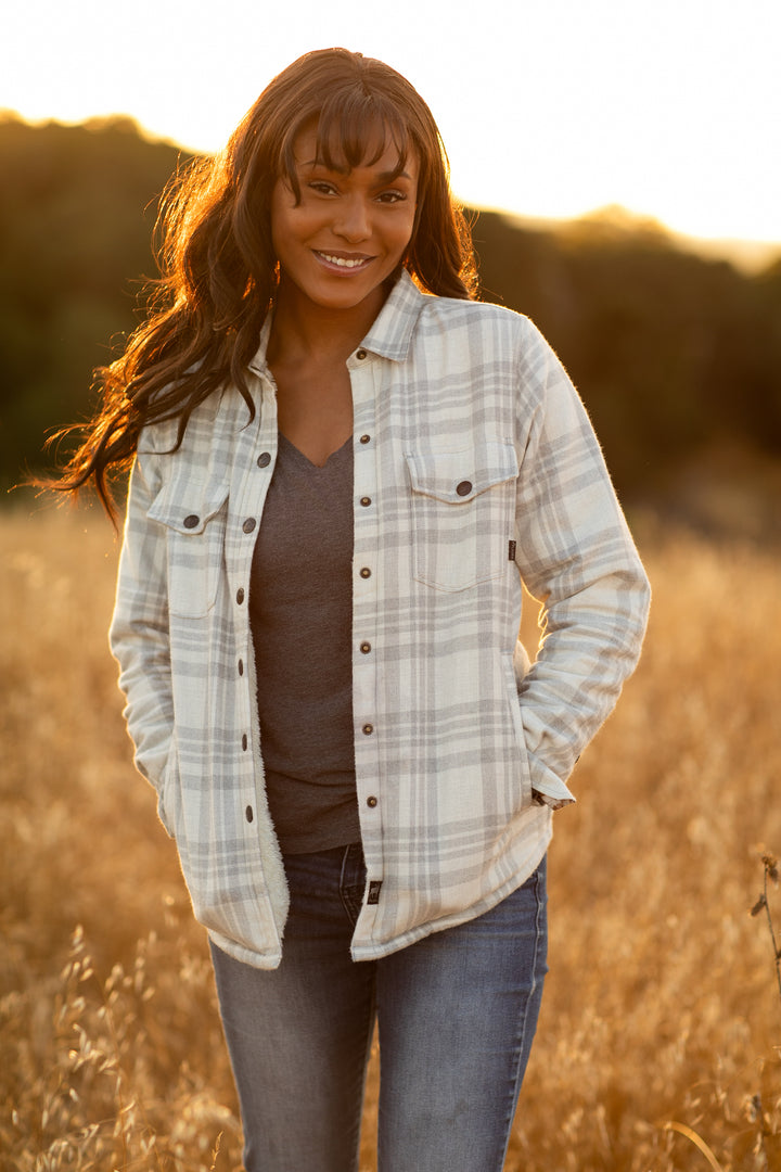 Woman smiling outdoors in a field, wearing the Pladra Women&