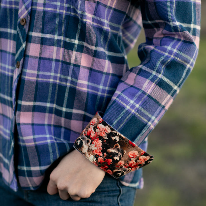 Woman in Pladra Every Day Flannel Shirt in Blackberry Purple plaid, floral cuffs, hand in pocket.
