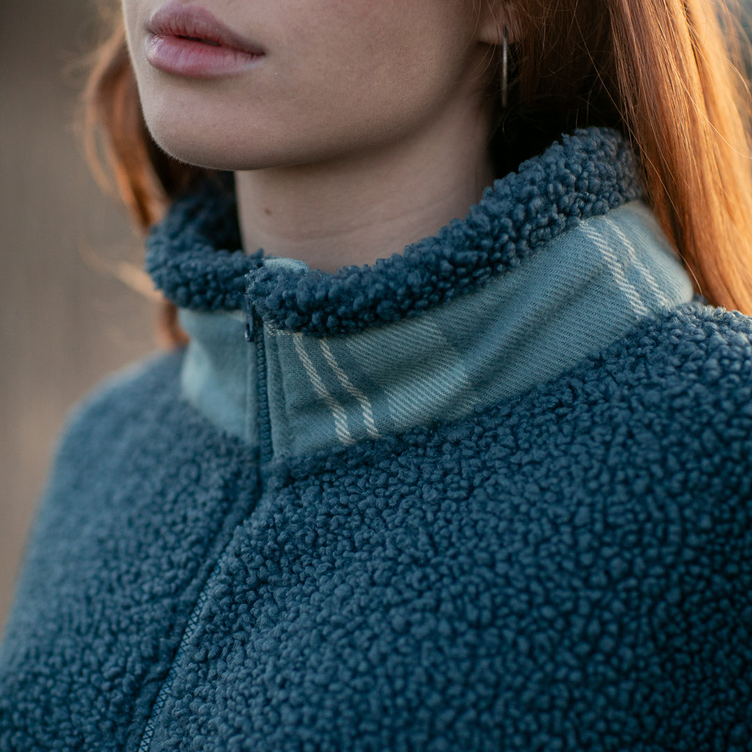 Close-up of a woman with long red hair wearing the Women&
