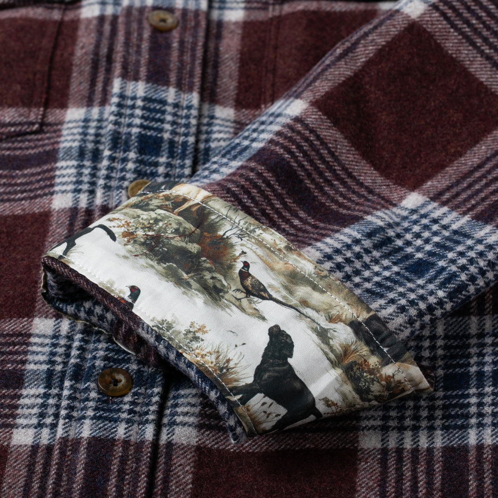 Pladra’s Workhorse Wool Flannel in Redwood Red features a nature-scene cuff lining with birds and trees for outdoor flair.