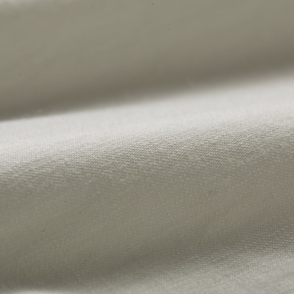 Close-up of the Men’s Short Sleeve Tailwinds Shirt in Sand White Chambray, showcasing its soft, smooth cotton fabric, detailed weave, and gentle folds that highlight subtle shadows on the surface.