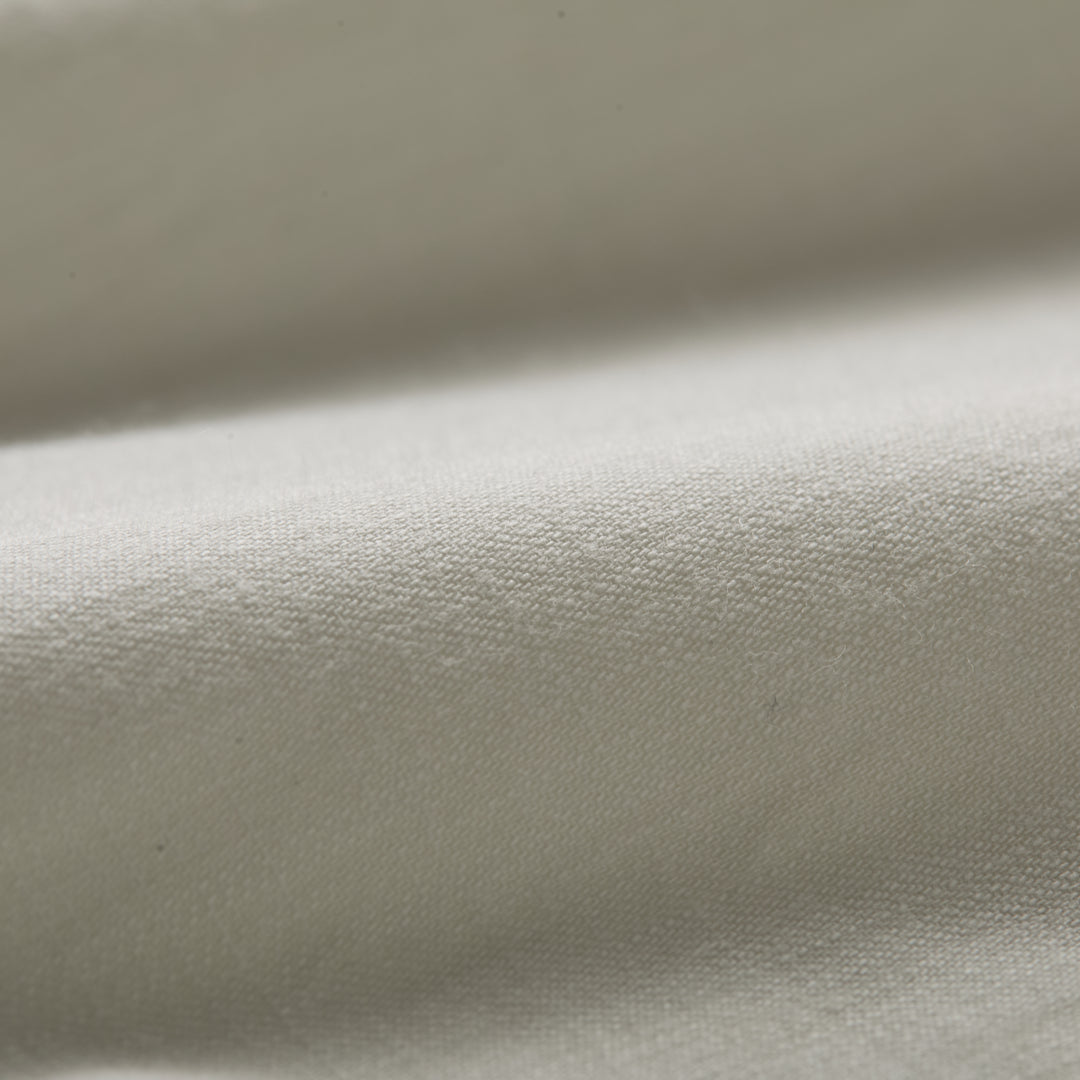 Close-up of the Men’s Short Sleeve Tailwinds Shirt in Sand White Chambray, showcasing its soft, smooth cotton fabric, detailed weave, and gentle folds that highlight subtle shadows on the surface.