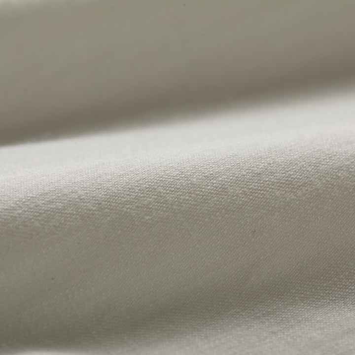 Close-up of the Men’s Short Sleeve Tailwinds Shirt in Sand White Chambray, showcasing its soft, smooth cotton fabric, detailed weave, and gentle folds that highlight subtle shadows on the surface.