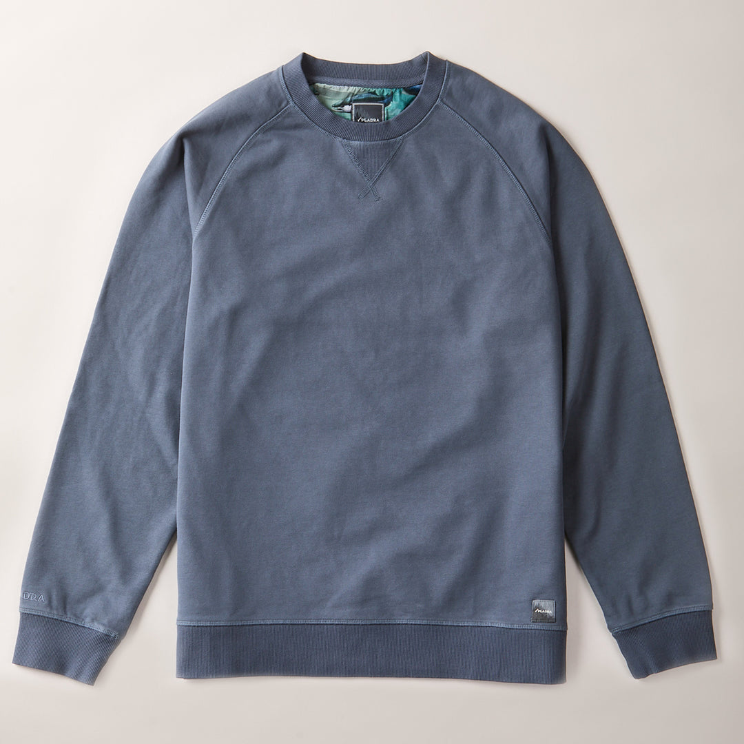 The Pladra Men's Klamath Crew in Stone Blue is a classic-fit, long-sleeve sweatshirt laid flat on a light surface.