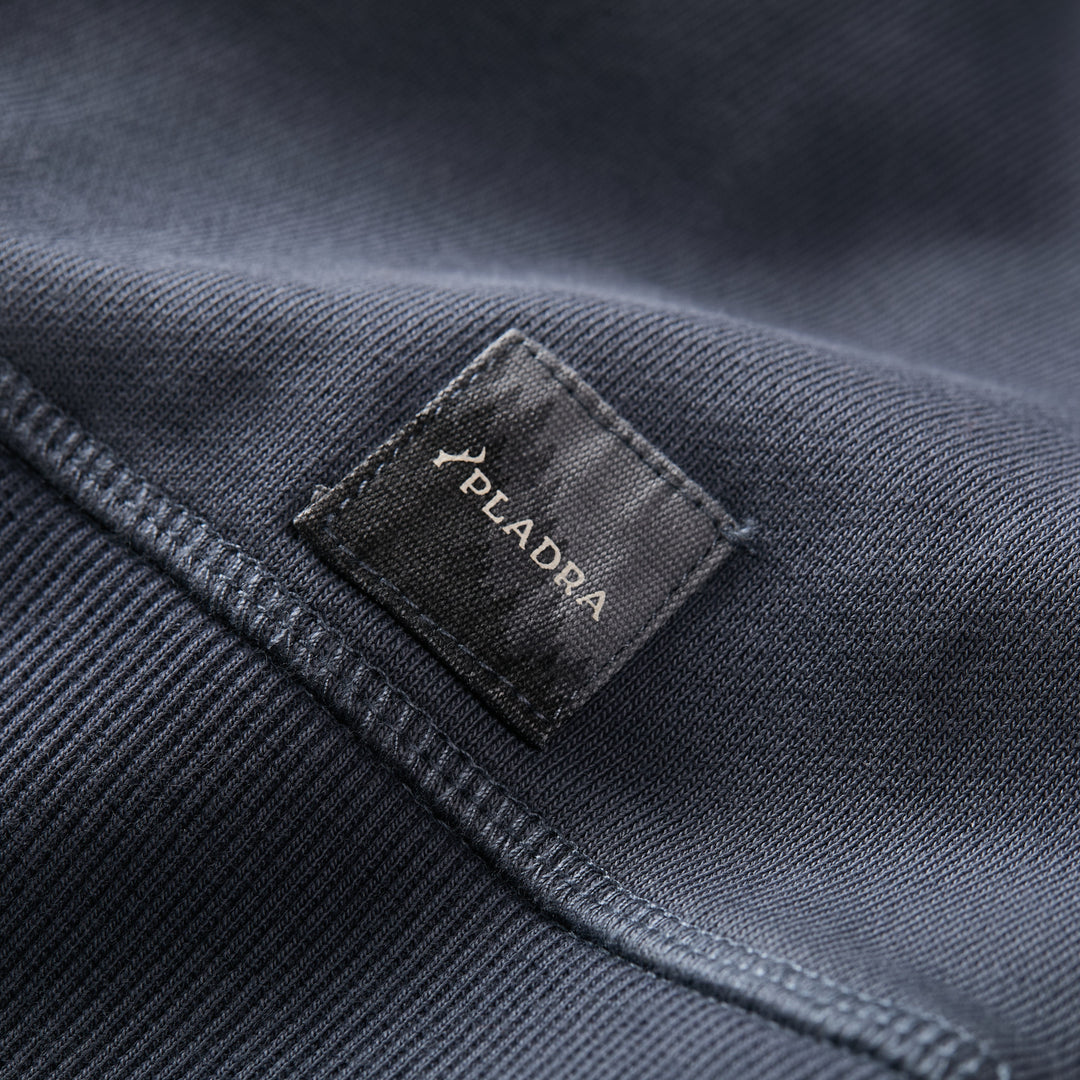 A close-up of the Men’s Klamath Crew in Stone Blue by Pladra, featuring a black Pladra label.