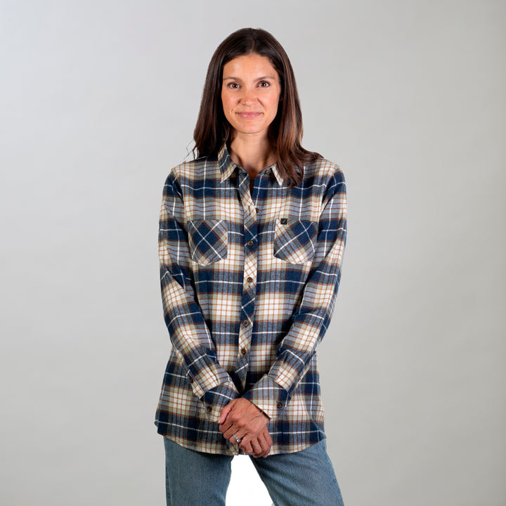 A woman with straight brown hair stands against a light background, wearing the Women&