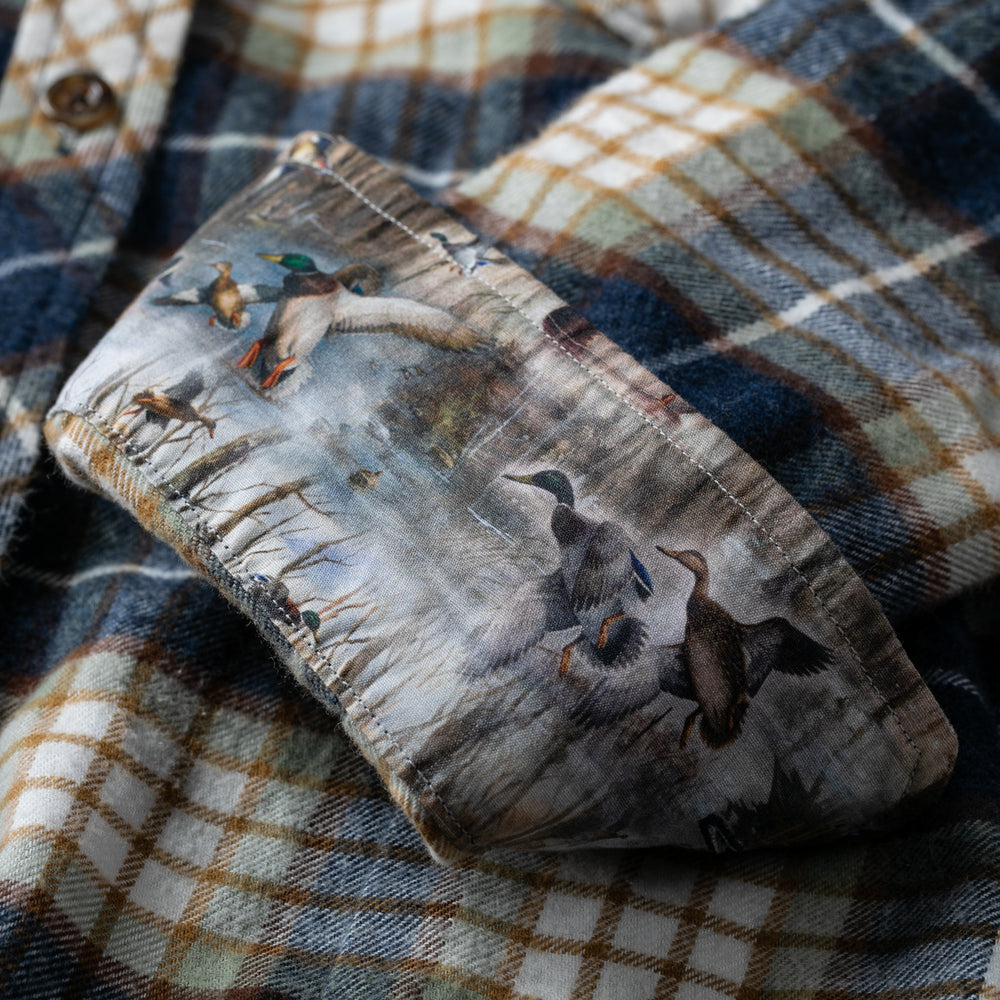 A close-up of the Women's Every Day Flannel Shirt in Banff Blue shows a turned-up cuff, revealing a duck-by-pond print inner lining. Crafted from premium cotton, this shirt blends comfort with style.