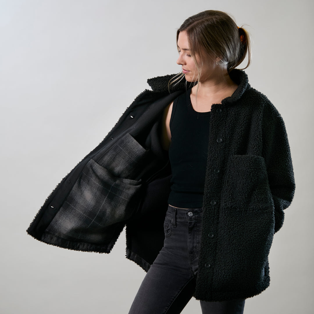 A woman in black pants models the Women&