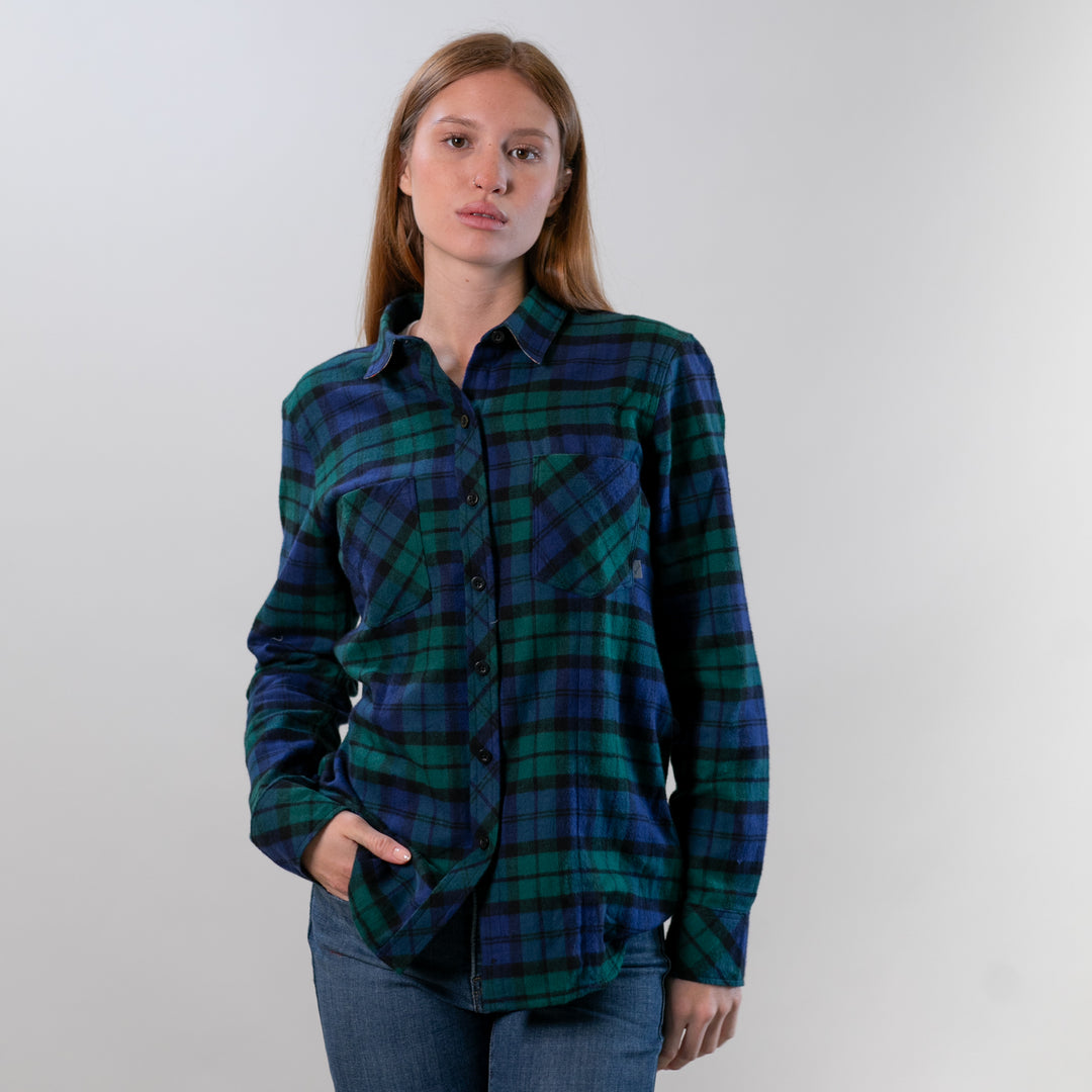 A woman models the Pladra Women's Every Day Flannel Shirt in Bolinas Blue, wearing jeans with one hand in her pocket.