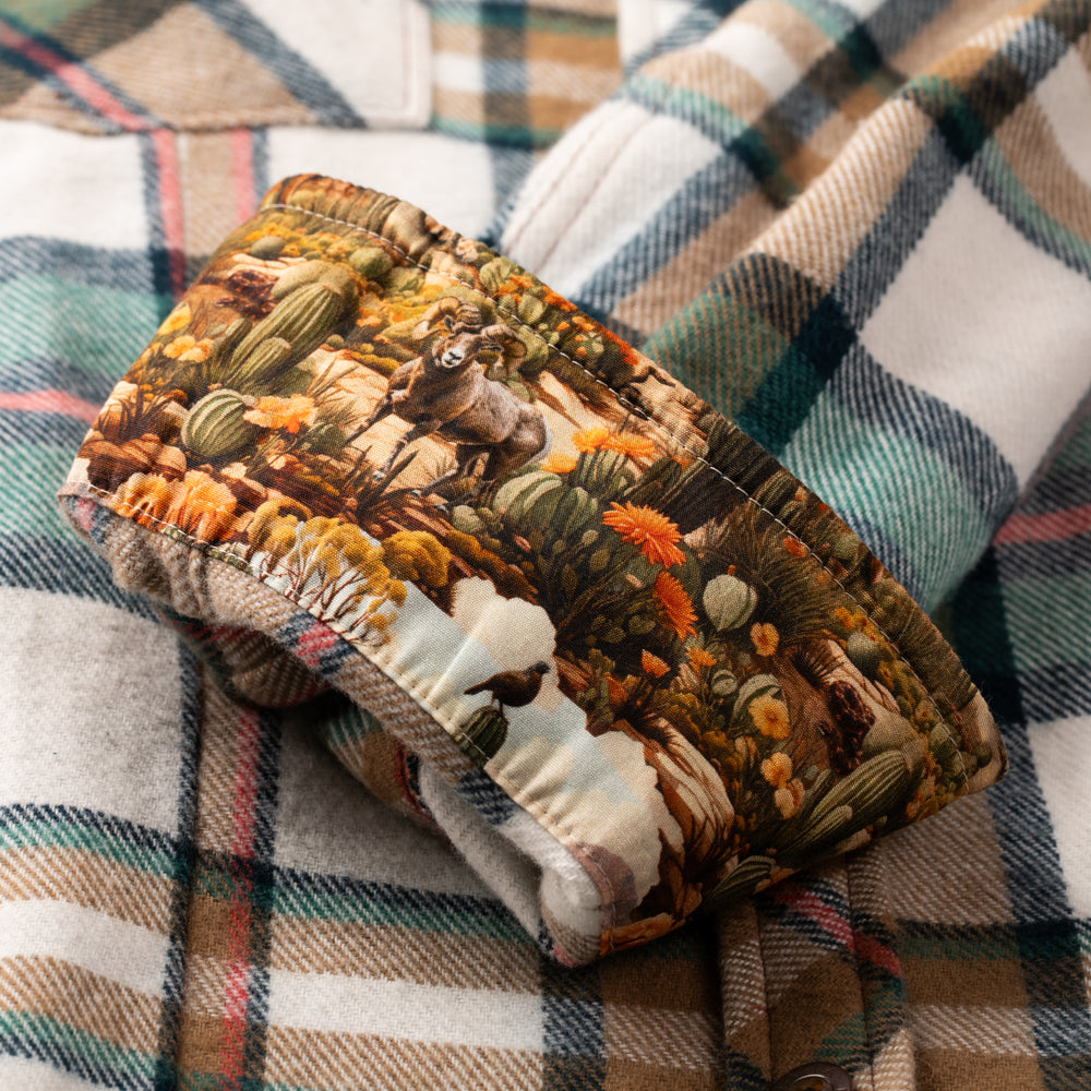 A horse and cactus headband rests on a Pladra Women's Every Day Elite Flannel Shirt in Coyote Tan.
