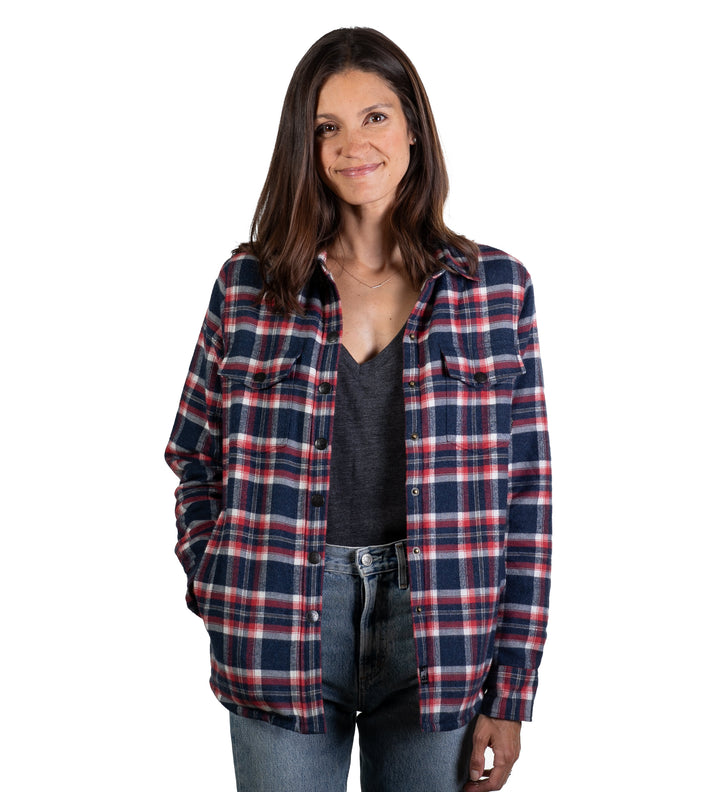 A woman with brown hair smiles with one hand in her pocket, wearing the Women&