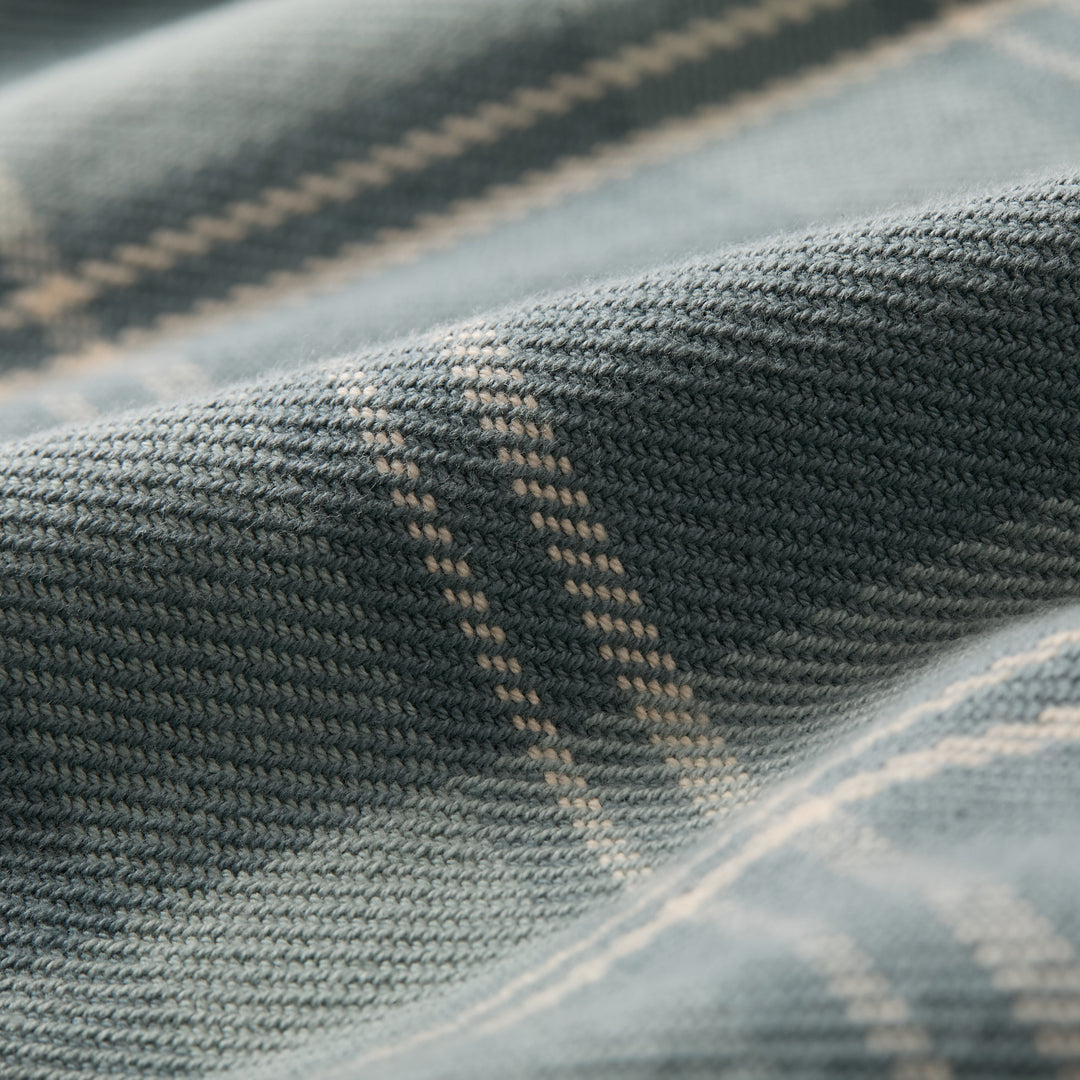 Close-up of dark green fabric with a textured knit and light plaid stripes, featuring gentle folds and soft lighting—ideal for the Women&