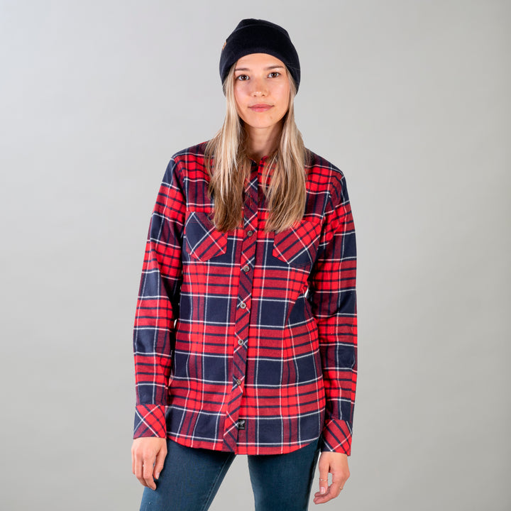 A woman with long, light brown hair in a black beanie, dark pants, and the Women&