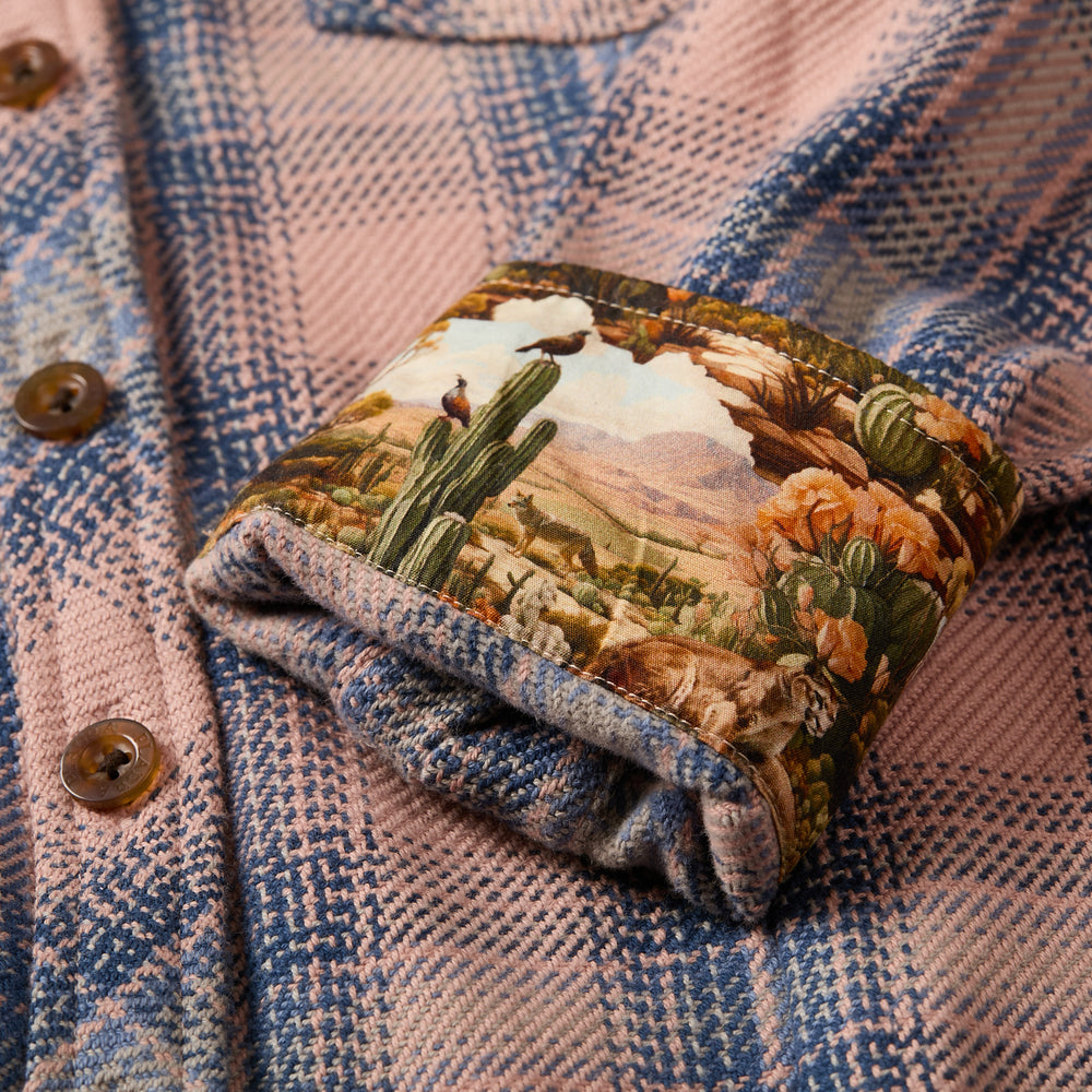 Close-up of Pladra's Women's Fireside Flannel in Lily Pink with a desert landscape pattern inside the cuff.