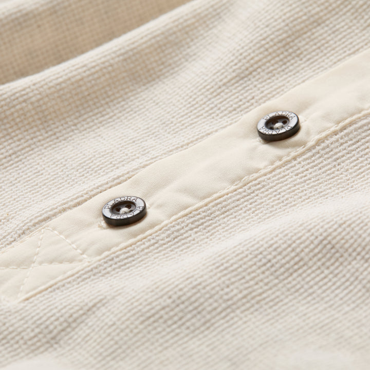 Close-up of two metal buttons on Pladra’s Women’s Elko Henley in Oatmeal White textured waffle cotton fabric.