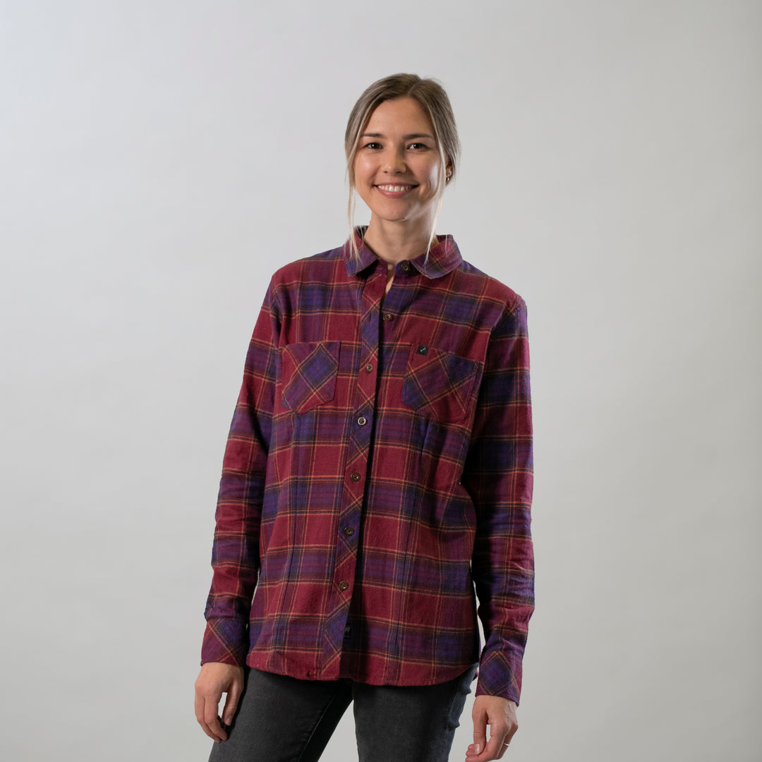 A smiling person wears the Pladra Women's Every Day Flannel Shirt in RK Plum Red against a light gray background.