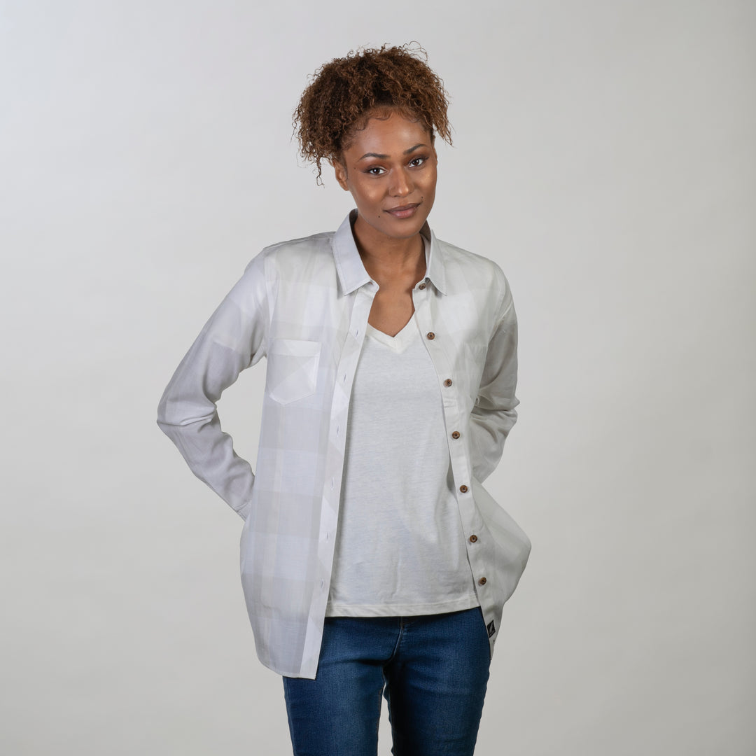 Woman with curly hair wears the Pladra Women's Breeze Shirt in Whisper Grey, facing the camera against a plain background.