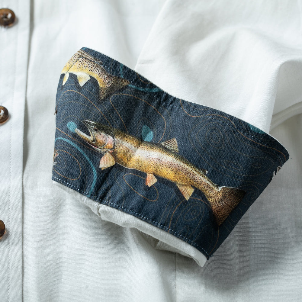 The Pladra Women's Breeze Shirt in Whisper Grey features cuffs with a colorful fish pattern on dark blue.