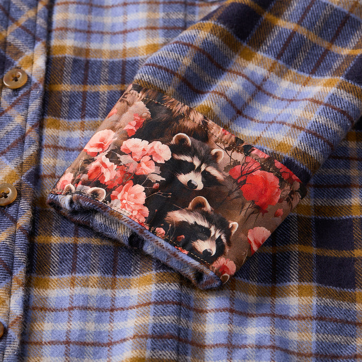 Floral-patterned pocket on a plaid shirt with raccoon design