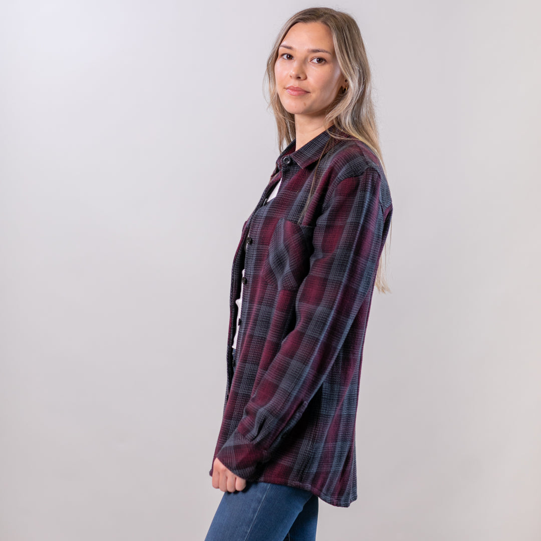 Woman wearing a plaid shirt against a plain background