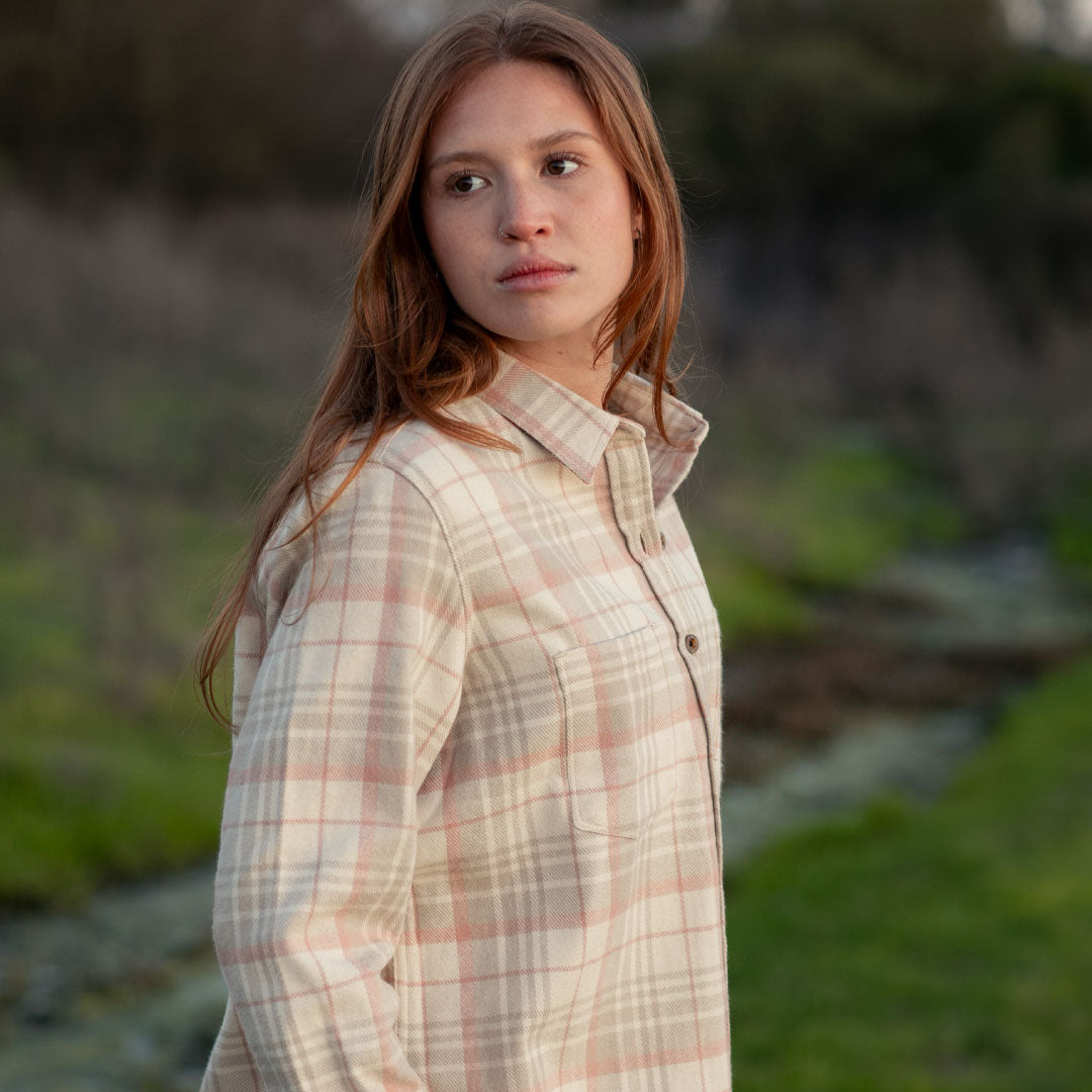 A woman with long reddish-brown hair wears the Women&