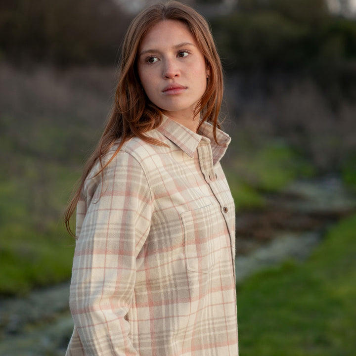 A woman with long reddish-brown hair wears the Women&