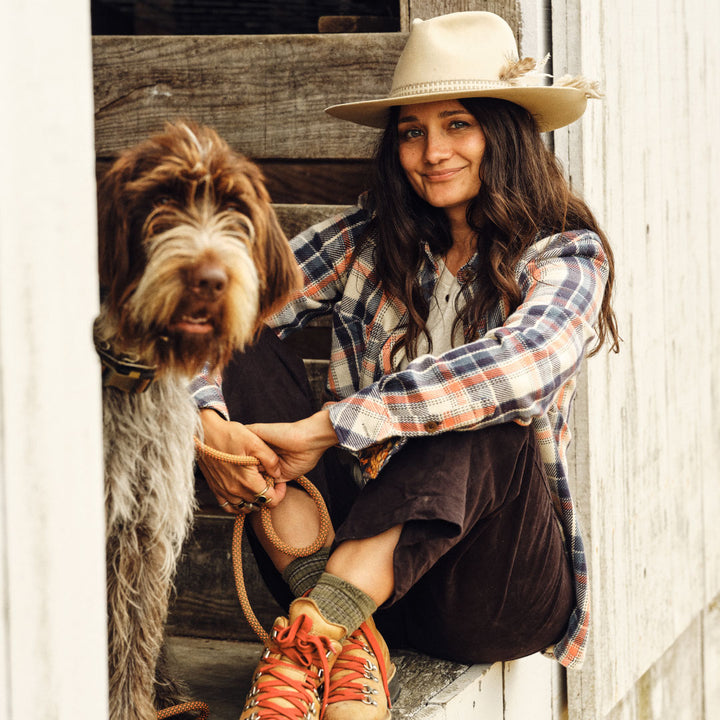 Woman sitting with a dog in a rustic setting
