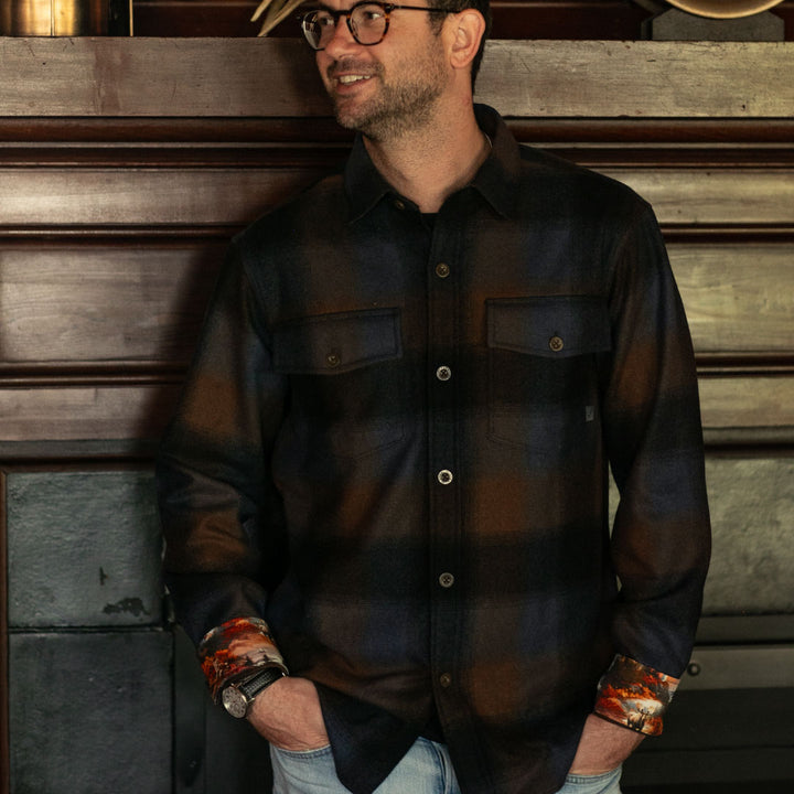 Man in glasses smiles, hands in pockets, wearing Pladra Men&