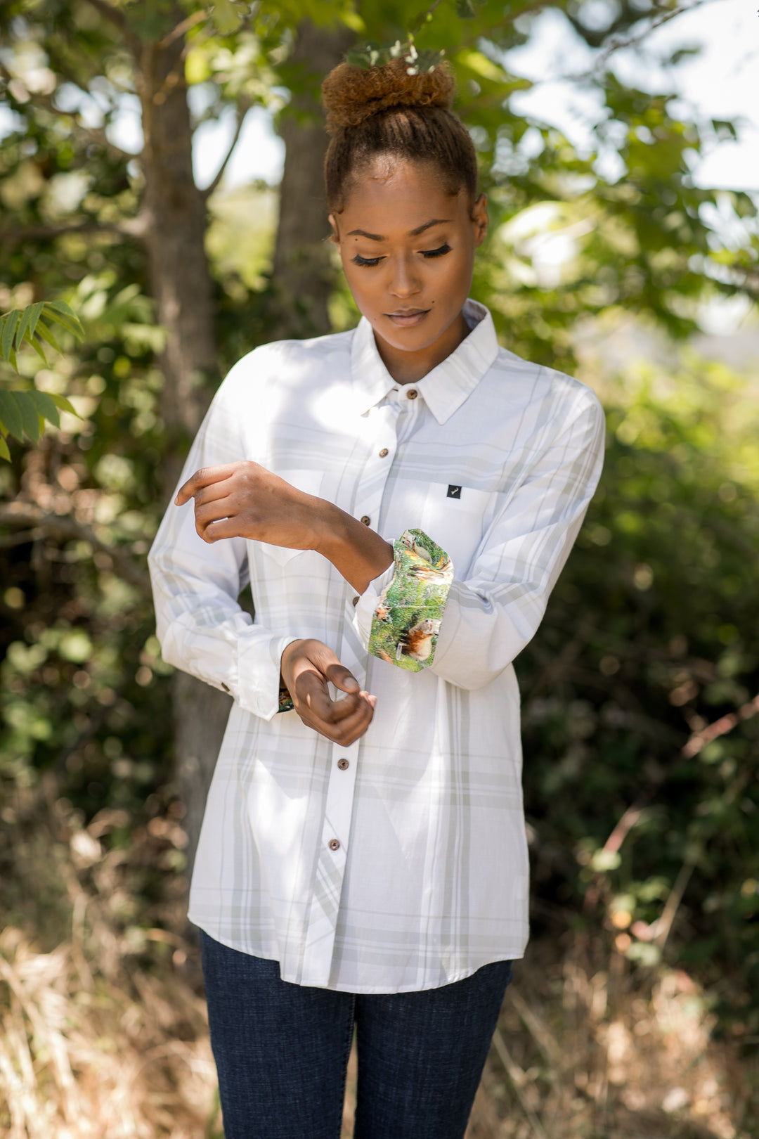 A woman outdoors adjusts the cuff of her Pladra Women&