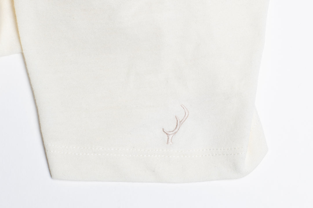 Close-up of Pladra Women’s V-Neck Tri-Blend Tee in Marshmallow White Heather with subtle hem embroidery.