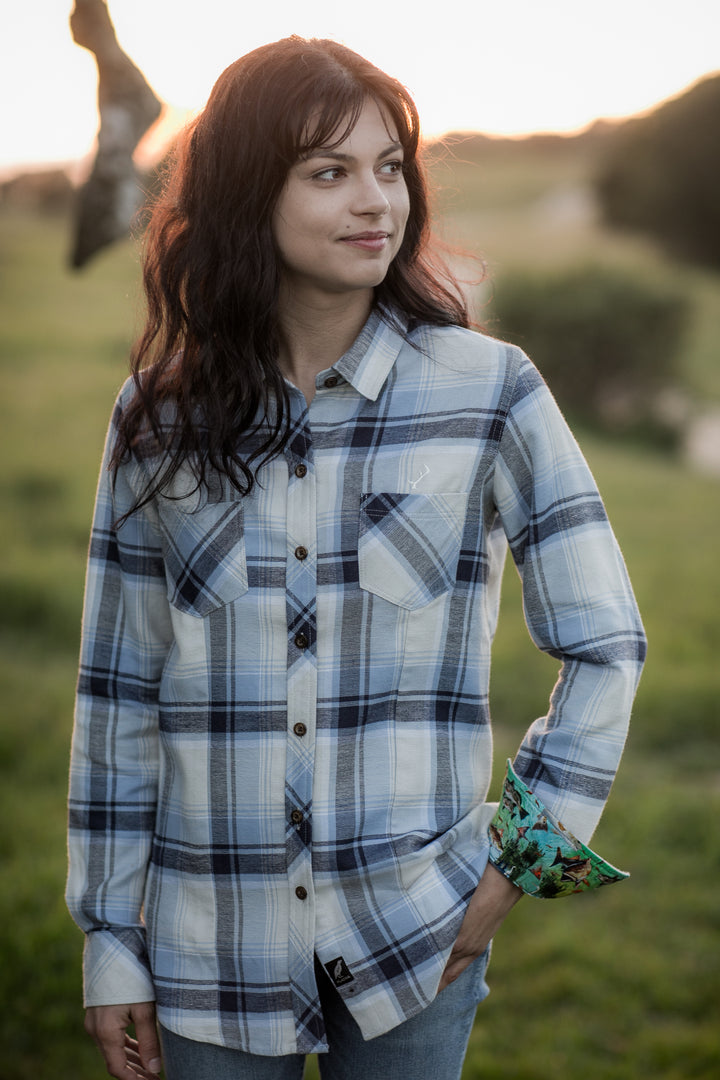 Woman in Pladra’s Women’s Every Day Double Weave Shirt in Birch White stands outside at sunset, looking to the side.