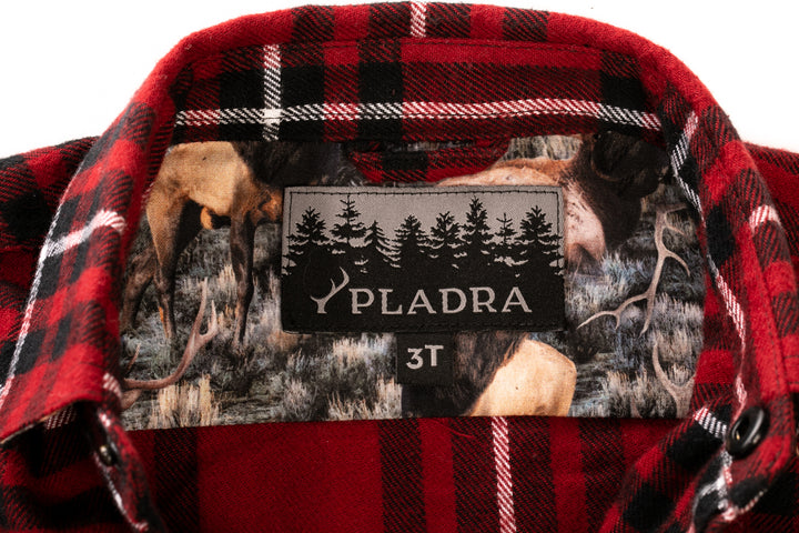 Close-up of a Toddler Cubs Flannel Shirt- Rocky Red collar with size 3T and PLADRA label. Made from premium red and black plaid cotton, it features an inner liner with deer and trees in a natural setting.