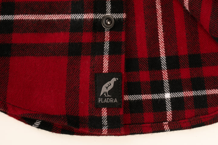 A close-up of the Toddler Cubs Flannel Shirt- Rocky Red, a premium cotton flannel in red, black, and white plaid with a black button and a black Pladra brand tag featuring a bird logo.